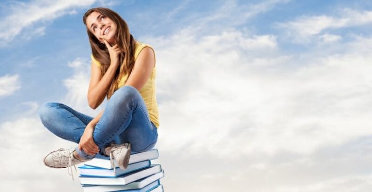 Young pretty woman thinking and sitting on a big books pile