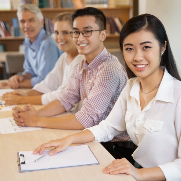 Positive people smiling at camera in library