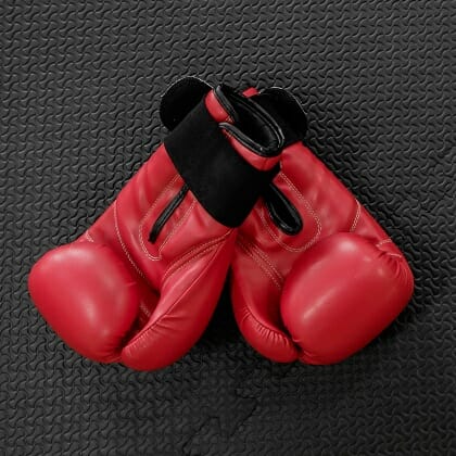 boxing gloves hang on nail on texture wall with copy space for t