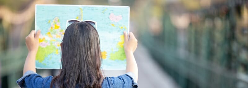 Female tourists on hand have a happy travel map.