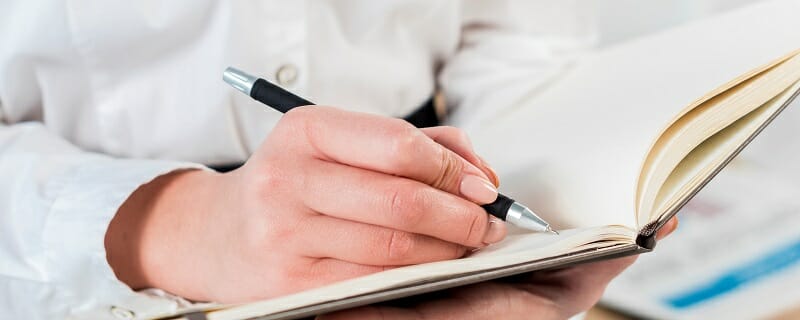 Close up of student taking notes in a notebook