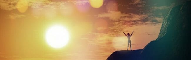 3D female on top of a cliff against a sunset sky