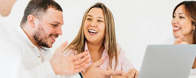 Group of smiling people in front of a computer