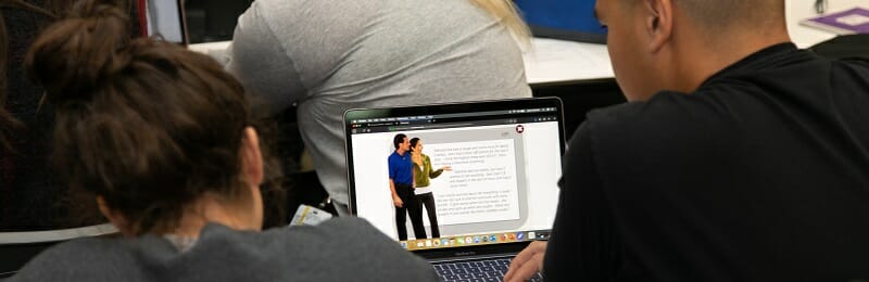 Students looking at case study on laptop