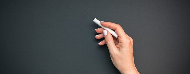 Teacher hand with piece of chalk