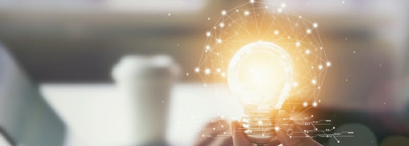 Hand holding light bulb with innovative and creativity are keys to success. Concept knowledge leads to ideas and inspiration.