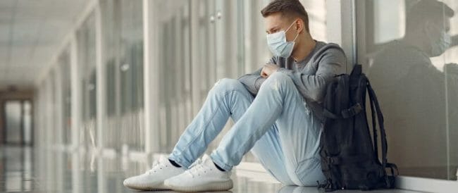 Man in a mask sitting in the hall of hospital