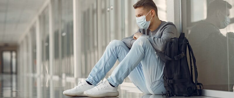 Man in a mask sitting in the hall of hospital