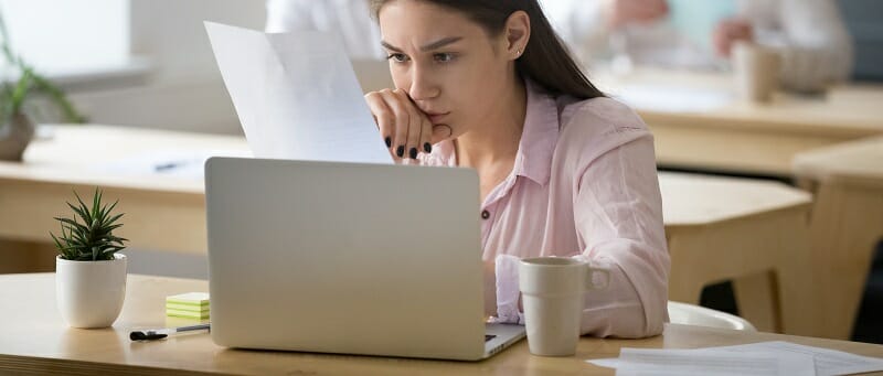 Serious employee attentively reading document focused on thinkin