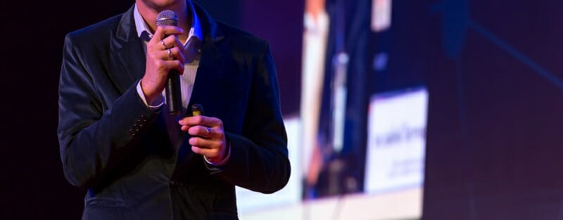 Speaker giving a talk in conference hall at business event. Audi